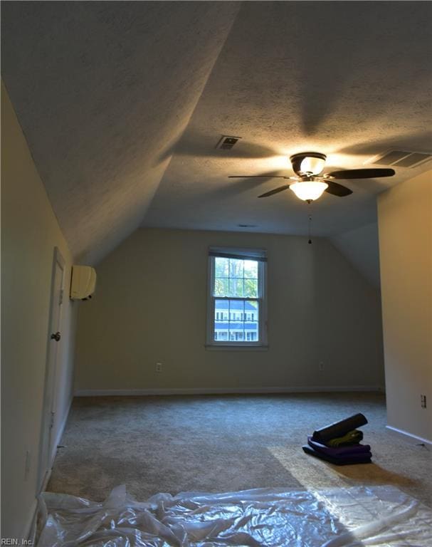bonus room featuring ceiling fan, a wall unit AC, baseboards, lofted ceiling, and carpet flooring