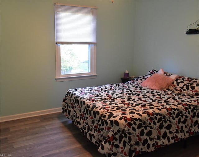 bedroom with baseboards and wood finished floors