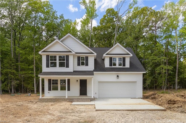 traditional-style home featuring a garage, a shingled roof, driveway, and covered porch