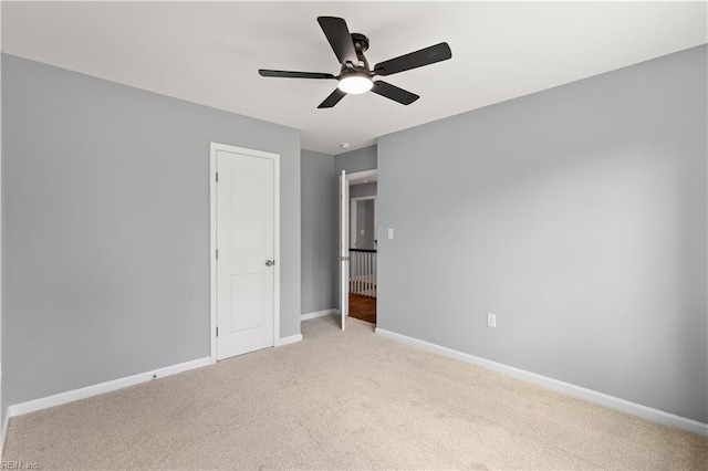 unfurnished bedroom featuring a ceiling fan, baseboards, and light carpet