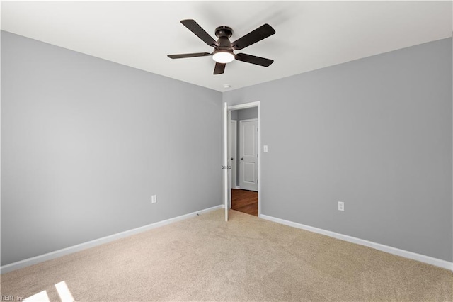unfurnished bedroom featuring light colored carpet, baseboards, and ceiling fan