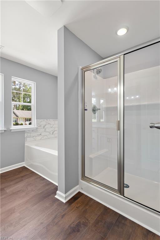 bathroom with baseboards, a stall shower, and wood finished floors