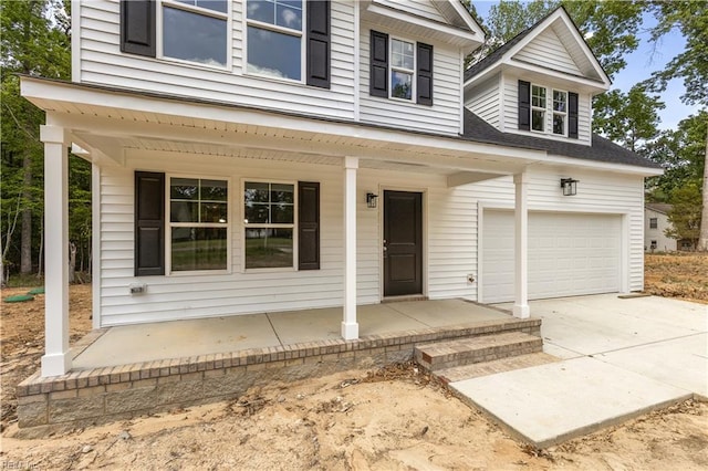 view of front facade featuring an attached garage, covered porch, and concrete driveway