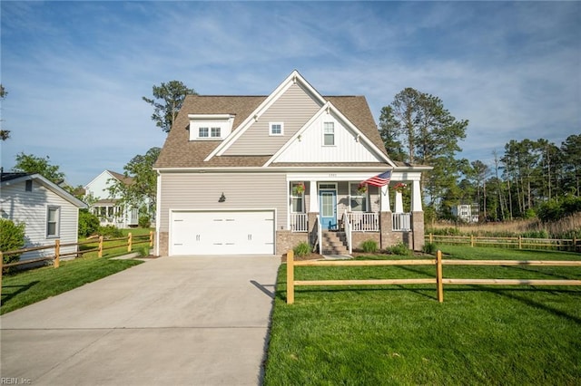 craftsman inspired home with covered porch, fence, driveway, and a front lawn