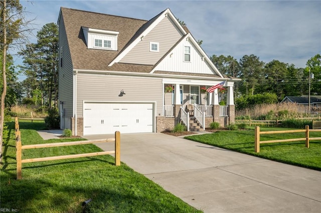 view of front facade with a garage, concrete driveway, a porch, and a front yard
