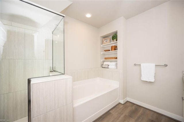 bathroom featuring a walk in shower, built in shelves, baseboards, wood finished floors, and a bath