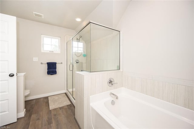bathroom with visible vents, a garden tub, wood finished floors, toilet, and a stall shower