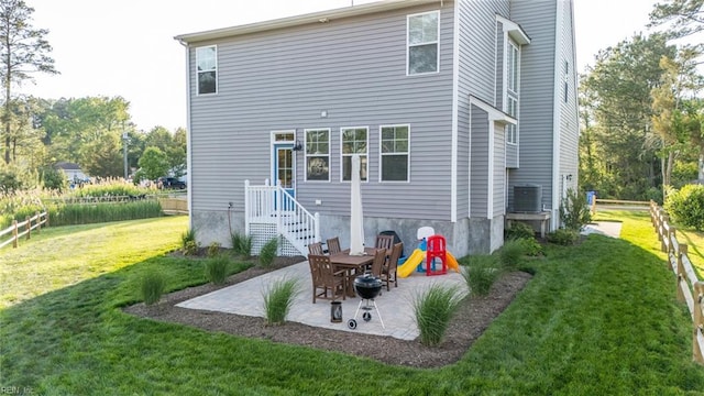 rear view of property featuring a lawn, a patio, fence, and central air condition unit
