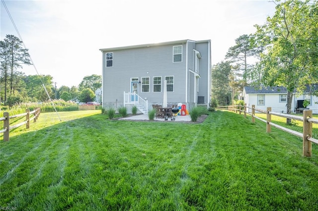 back of property with a lawn, a patio area, and fence