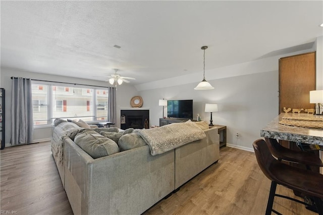 8550 Tidewater Dr Unit I2, Norfolk, VA 23503 - living area featuring baseboards, a fireplace, a ceiling fan, and light wood-type flooring