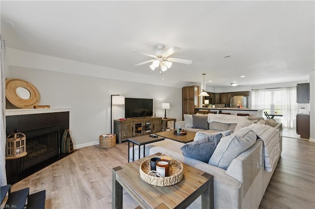 8550 Tidewater Dr Unit I2, Norfolk, VA 23503 - living room with ceiling fan, a fireplace with flush hearth, baseboards, and light wood-type flooring