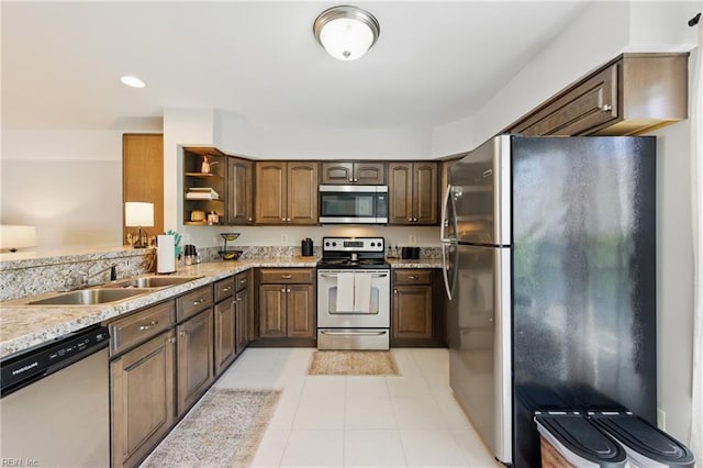 8550 Tidewater Dr Unit I2, Norfolk, VA 23503 - kitchen featuring open shelves, a sink, light tile patterned floors, light stone counters, and stainless steel appliances