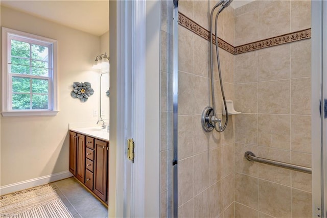 full bath featuring vanity, tile patterned flooring, baseboards, and a stall shower