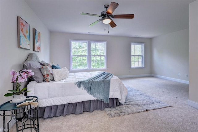 carpeted bedroom with baseboards, visible vents, and ceiling fan