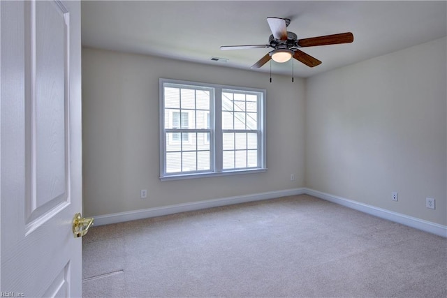 carpeted empty room featuring ceiling fan, visible vents, and baseboards