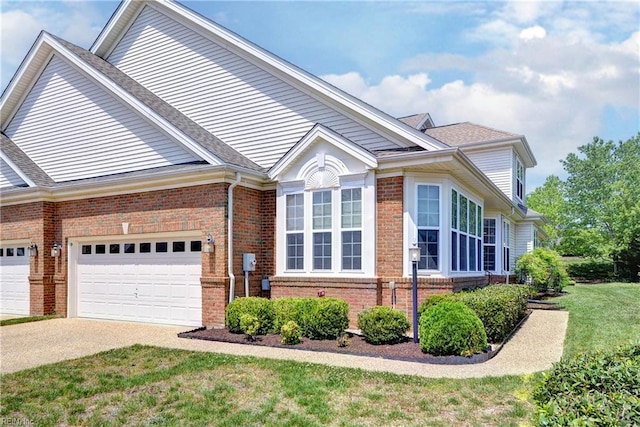 view of front of house with brick siding, driveway, a front lawn, and a garage