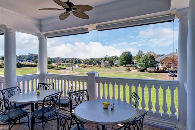 wooden terrace featuring outdoor dining space, ceiling fan, and a yard