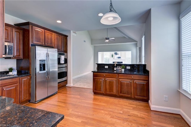 kitchen featuring a ceiling fan, appliances with stainless steel finishes, hanging light fixtures, baseboards, and lofted ceiling