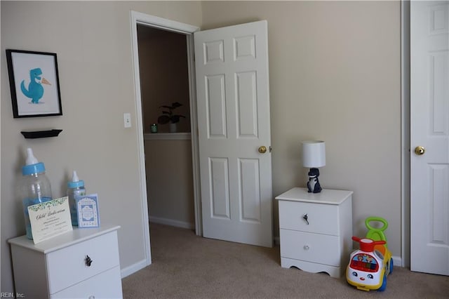 bedroom with light colored carpet and baseboards