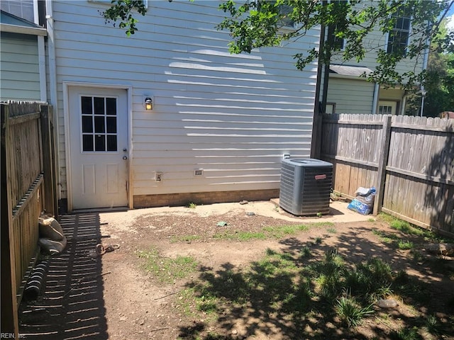 view of side of home featuring central AC unit and a fenced backyard