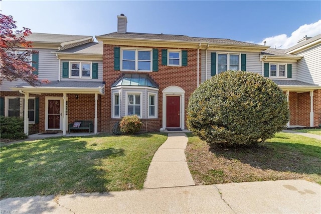 117 Gnarled Oak Ln, Yorktown, VA 23692 - townhome / multi-family property with a chimney, a front yard, and brick siding
