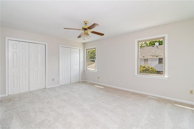 117 Gnarled Oak Ln, Yorktown, VA 23692 - unfurnished bedroom featuring multiple closets, baseboards, a ceiling fan, and carpet flooring