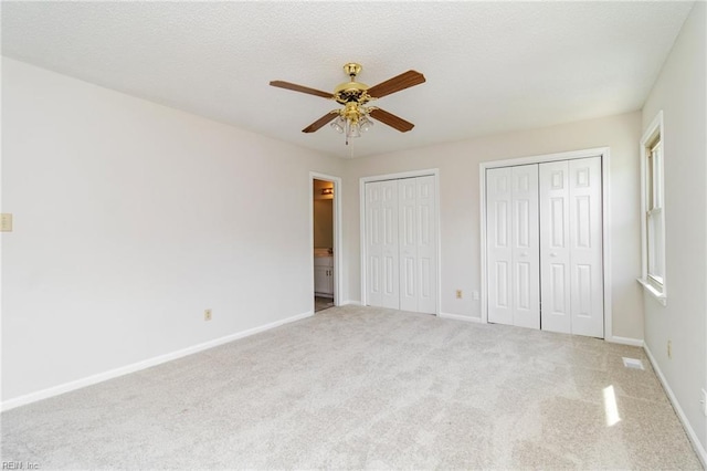 117 Gnarled Oak Ln, Yorktown, VA 23692 - unfurnished bedroom with two closets, a textured ceiling, baseboards, and carpet