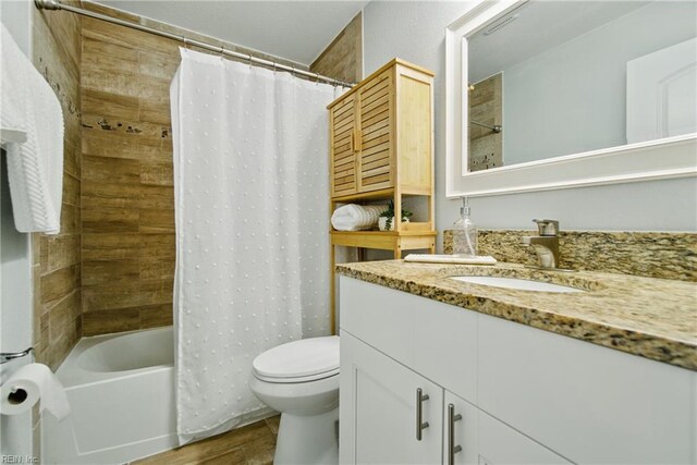 bathroom featuring vanity, toilet, wood finished floors, and shower / bath combination with curtain