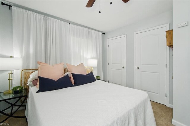 carpeted bedroom featuring baseboards and ceiling fan
