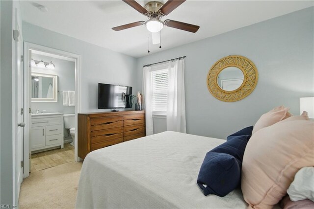 bedroom featuring ensuite bathroom, ceiling fan, and light carpet
