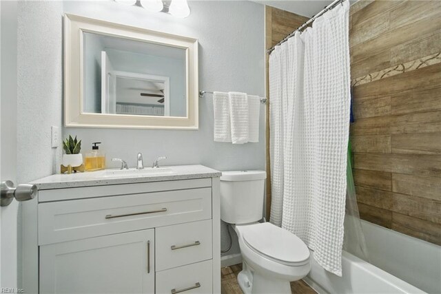 bathroom with vanity, shower / bathtub combination with curtain, and toilet