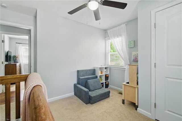 bedroom featuring baseboards, light carpet, and a ceiling fan