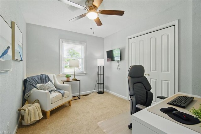 office with a ceiling fan, baseboards, and light carpet