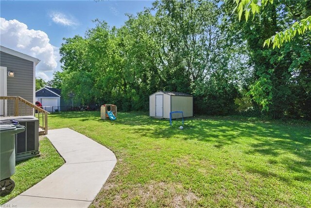 view of yard with fence, a storage unit, cooling unit, a playground, and an outdoor structure