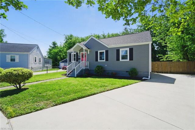 view of front of property featuring a front lawn, fence, crawl space, and concrete driveway