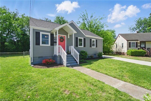 bungalow-style house featuring fence, a front yard, roof with shingles, and crawl space