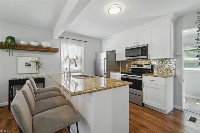 kitchen with baseboards, a sink, a wealth of natural light, and stainless steel appliances