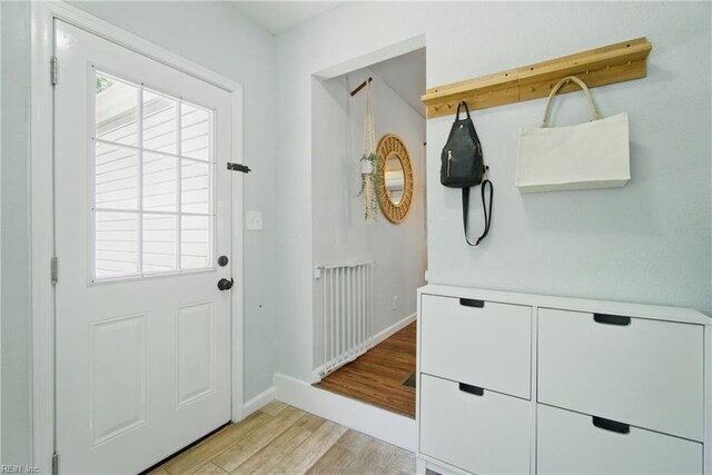 doorway featuring light wood-style floors and baseboards