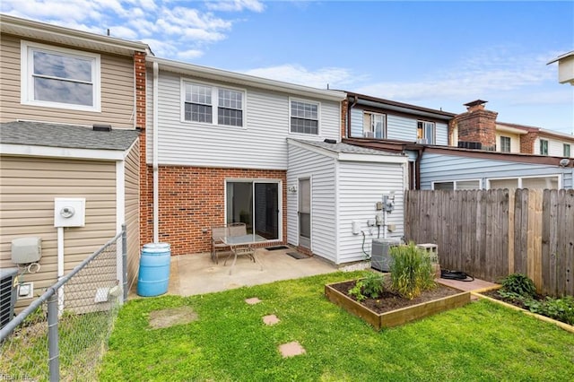 back of house with a lawn, a patio, and a fenced backyard