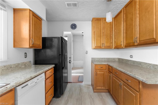 kitchen with visible vents, brown cabinetry, and dishwasher