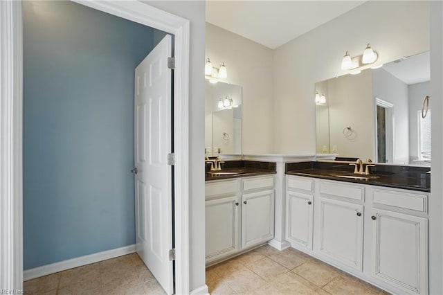 full bathroom featuring vanity, tile patterned flooring, and baseboards