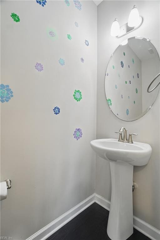 bathroom featuring baseboards and a sink