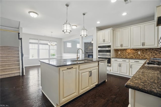 kitchen with dark wood-type flooring, a sink, tasteful backsplash, and stainless steel appliances