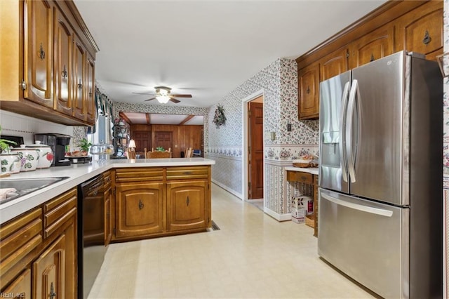 kitchen featuring a ceiling fan, light countertops, stainless steel fridge with ice dispenser, a peninsula, and wallpapered walls