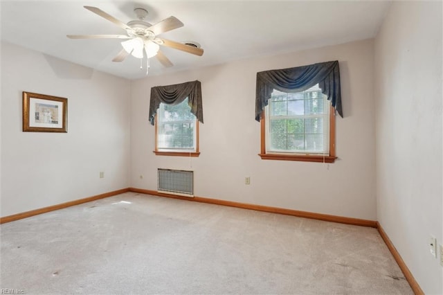 carpeted empty room with a ceiling fan, baseboards, and a wealth of natural light