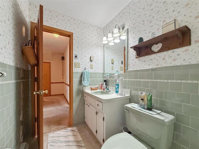 bathroom with wallpapered walls and tile walls