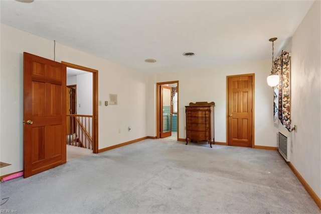spare room with baseboards, light colored carpet, and visible vents
