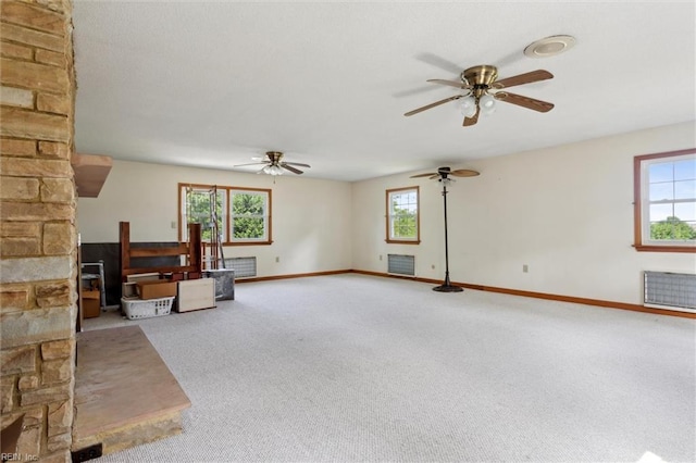 unfurnished living room featuring carpet floors, ceiling fan, and baseboards
