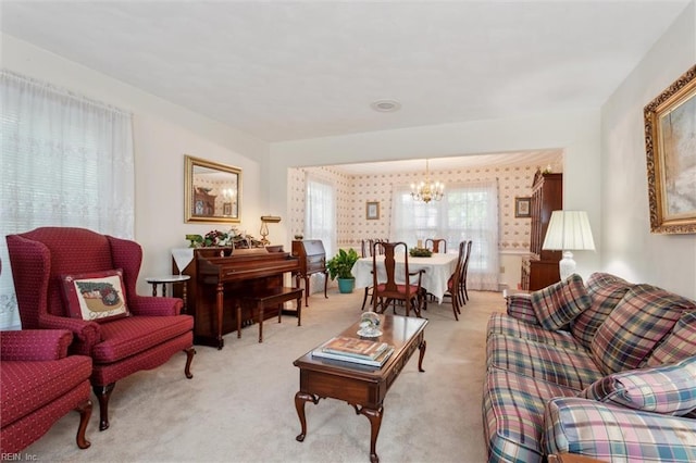 living area with an inviting chandelier and light colored carpet