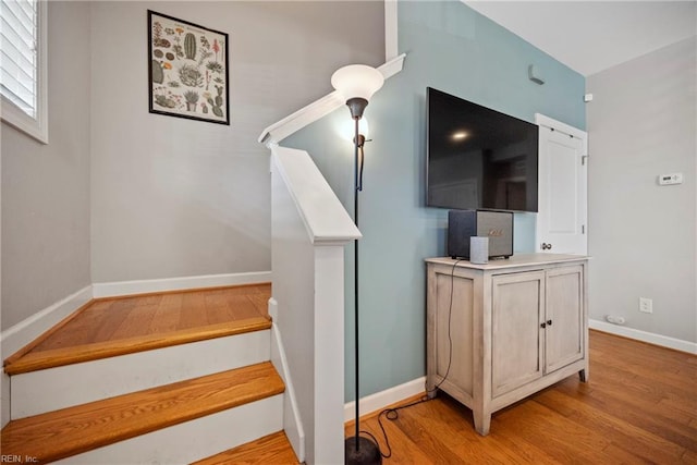 staircase with baseboards and wood finished floors